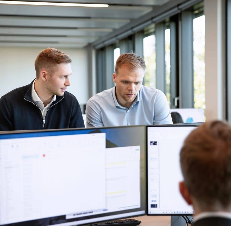 Mitarbeiter von FLEX Capital arbeiten an Computerbildschirmen.